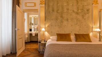 A hotel room with a large bed, a bedside table, a lamp, and a mirror.