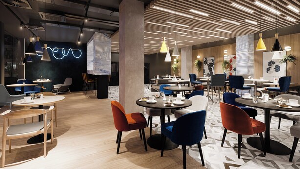 Un espace de restauration moderne avec des tables rondes, des chaises colorées et des luminaires suspendus.
