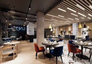 Un comedor moderno con mesas redondas, sillas coloridas e iluminación colgante.