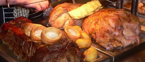 A roasted pork joint with Yorkshire puddings and roasted potatoes.
