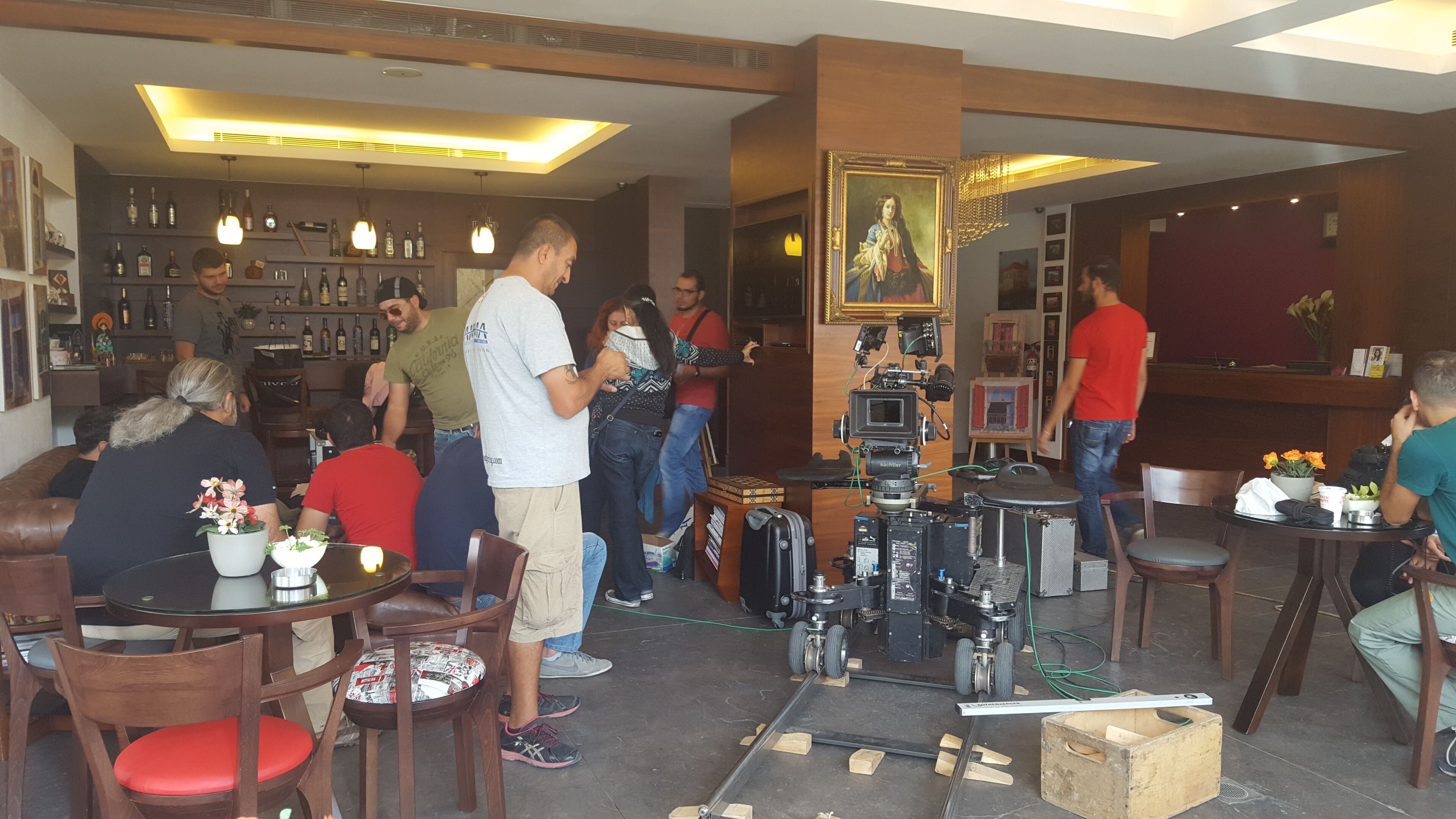 Un espace bar avec des meubles en bois, un équipement de tournage et un tableau accroché au mur.