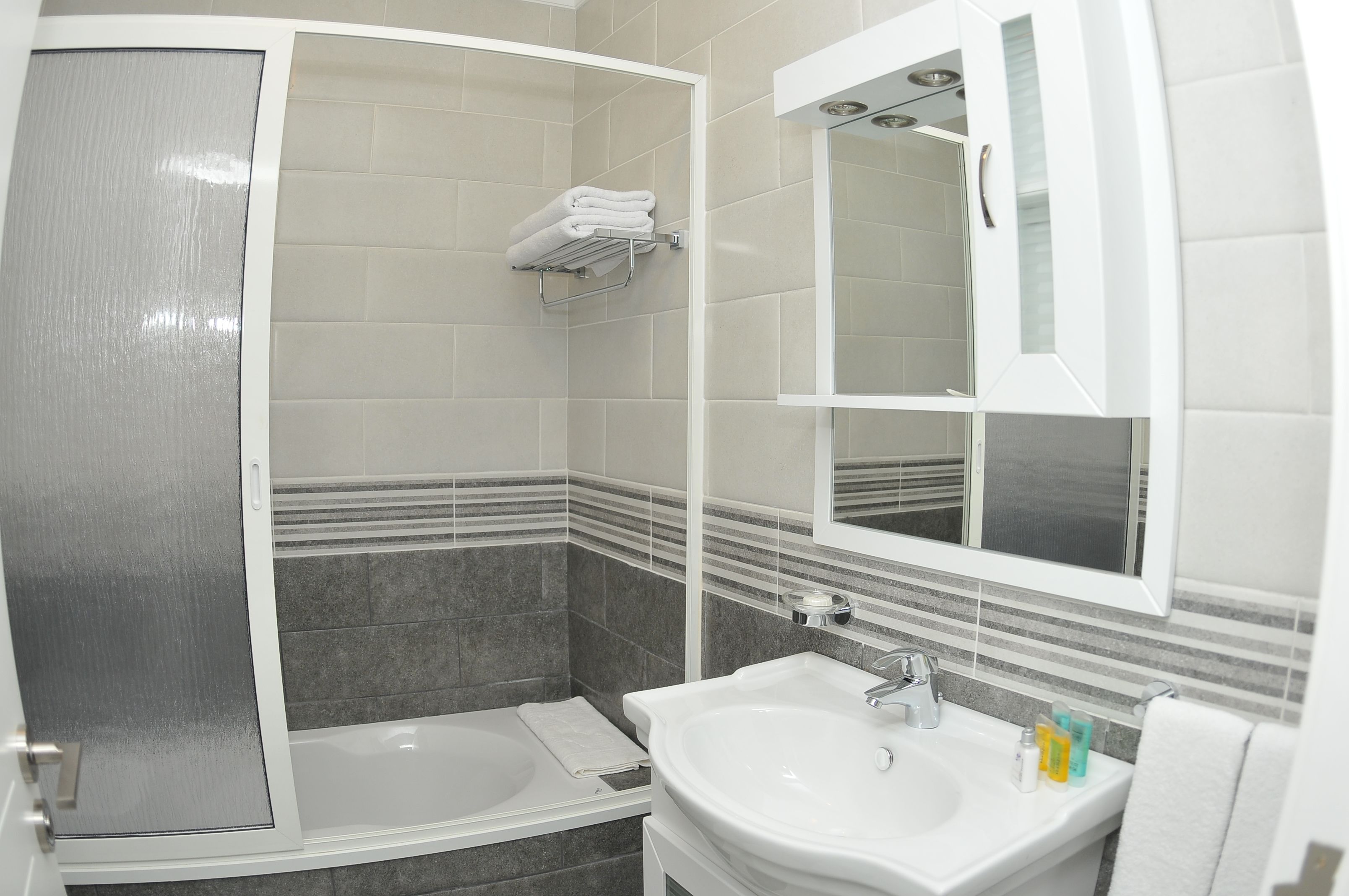 Un bany amb banyera, un lavabo i un mirall.