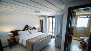 Une chambre d’hôtel comprenant un lit, des tables de chevet, une lampe, une vue sur l’extérieur et une salle de bain.