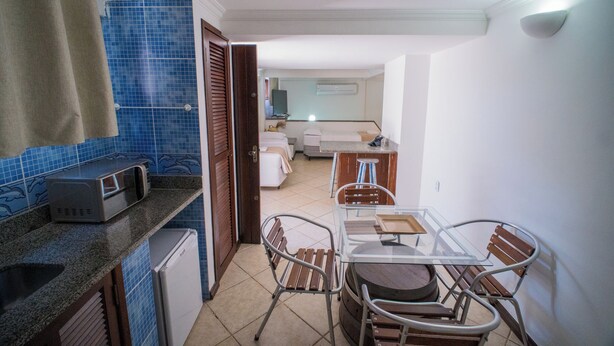 Una cocina compacta con refrigerador, microondas y una pequeña encimera.