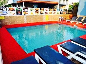 季节性开放的室外游泳池，池畔遮阳伞，日光浴躺椅