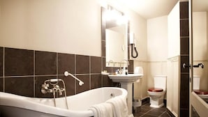 Un baño moderno con una bañera independiente, un lavamanos y un inodoro.