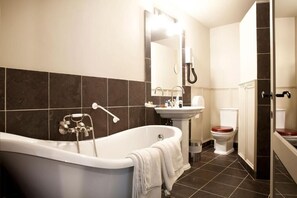 Een moderne badkamer met een vrijstaand bad, een wastafel en een toilet.