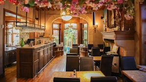 Interior de restaurante con barra, mesas para comer y vistas a través de las ventanas.