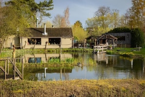 A lakeside building with a dock, a covered seating area, and a small boat. - Thermae Hotel Grimbergen  (Grimbergen)