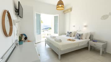 A bedroom with a bed, bedside table, and a view of the outdoors.