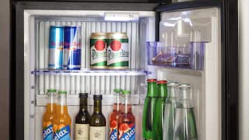 Un refrigerador con cerradura digital, que contiene diversas bebidas y aperitivos.