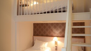 Un lit superposé avec une tête de lit, une lampe de chevet et un élément décoratif rouge sur le lit du bas.