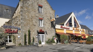 Un bâtiment en pierre comprenant une réception, un bar et un restaurant appelé « Le Relais du Roy ».