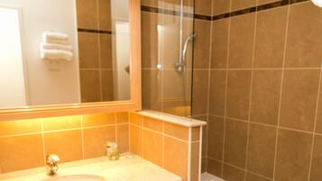 A bathroom with a sink, mirror, and bathtub.