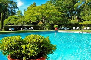 Una piscina al aire libre, sillones reclinables de piscina