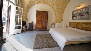 A bedroom with a stone ceiling, a bed, a wardrobe, and a wall-mounted sign.