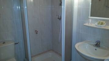Ein Badezimmer mit Dusche, Toilette und Waschbecken.