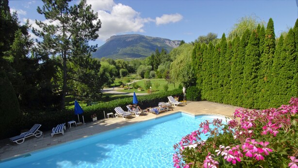 A swimming pool with lounge chairs and a view of a mountain.