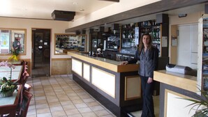 A bar area with a counter, seating, and a decorative butterfly on the wall.
