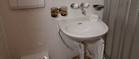 Un baño con inodoro, lavabo y ducha.