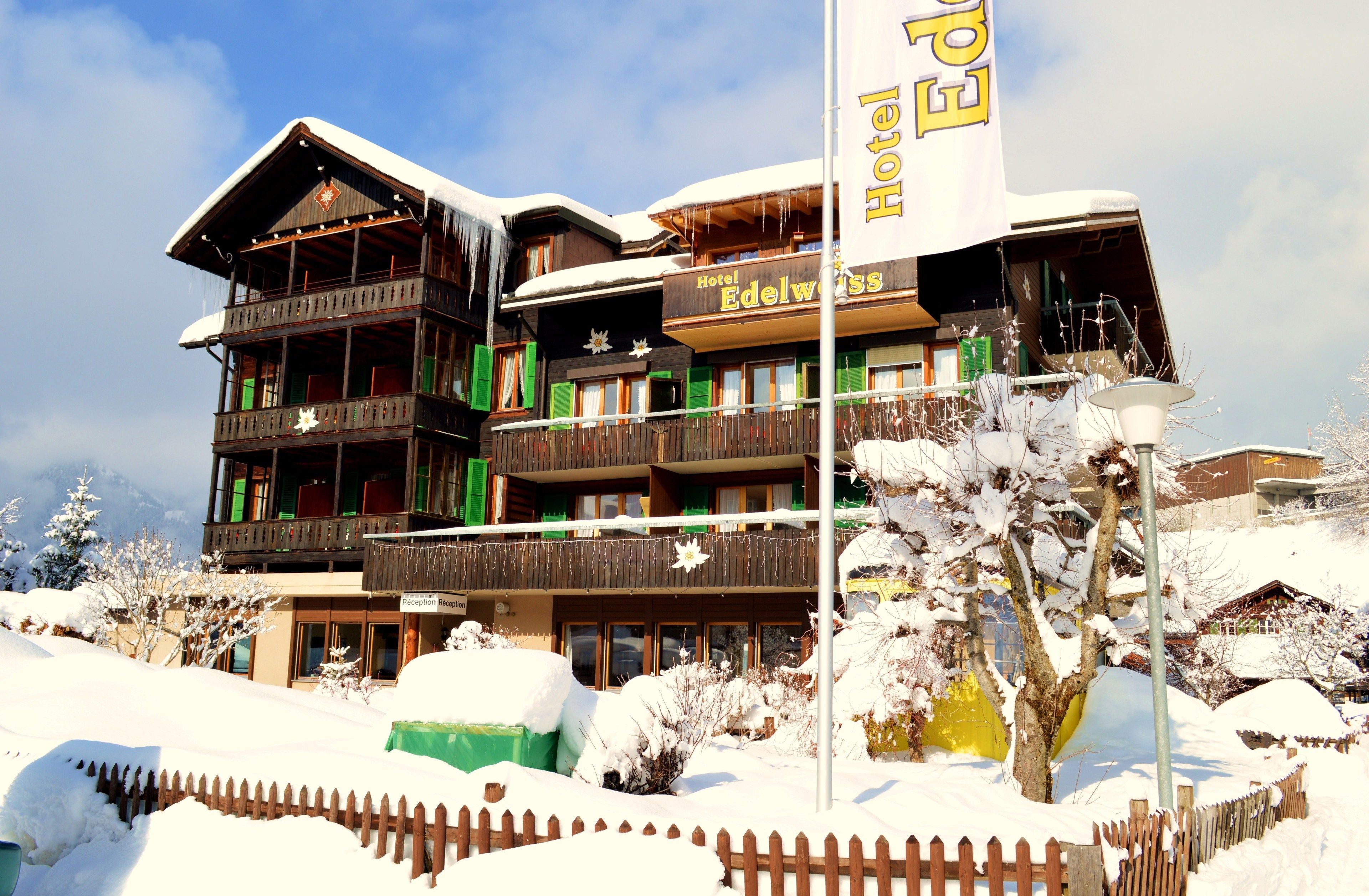 A multi-story hotel with balconies, a reception desk, and a snowy landscape.