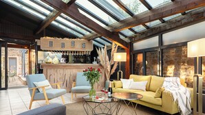 Un interior moderno con una zona de bar, asientos y una pared de piedra.