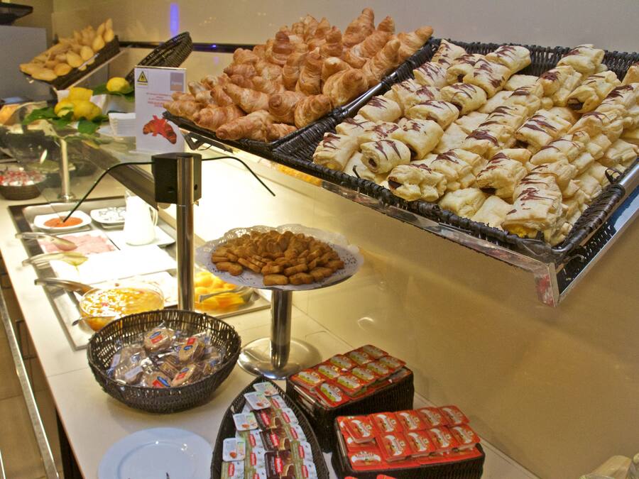 A buffet with various food items including pastries, sandwiches, and packaged goods.