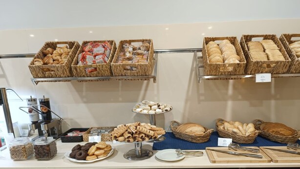 Ein Buffet mit verschiedenen Backwaren, darunter Brot, Gebäck und Kekse, präsentiert in Körben und auf einem Tisch.