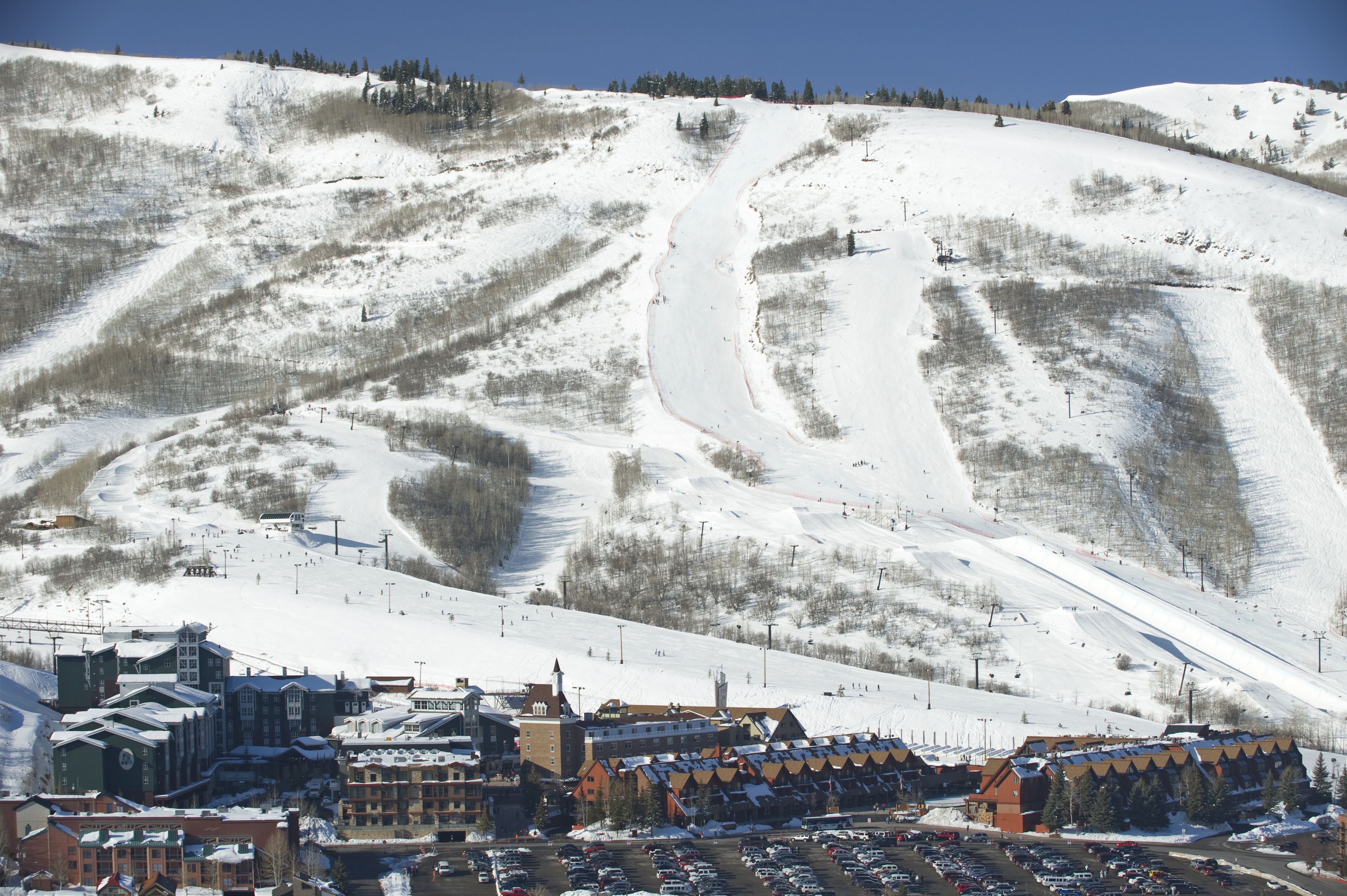 A ski resort with a main building, parking area, and ski slopes.