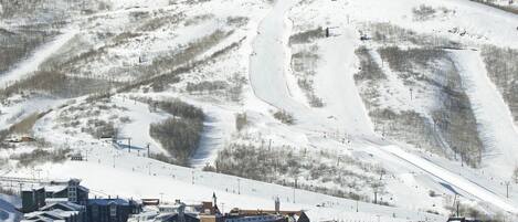 A ski resort with a main building, parking area, and ski slopes.
