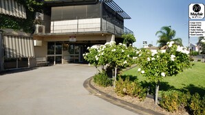 A motel with a two-story building, a covered entrance, and a sign indicating amenities like a heated pool, WiFi, and guest laundry.