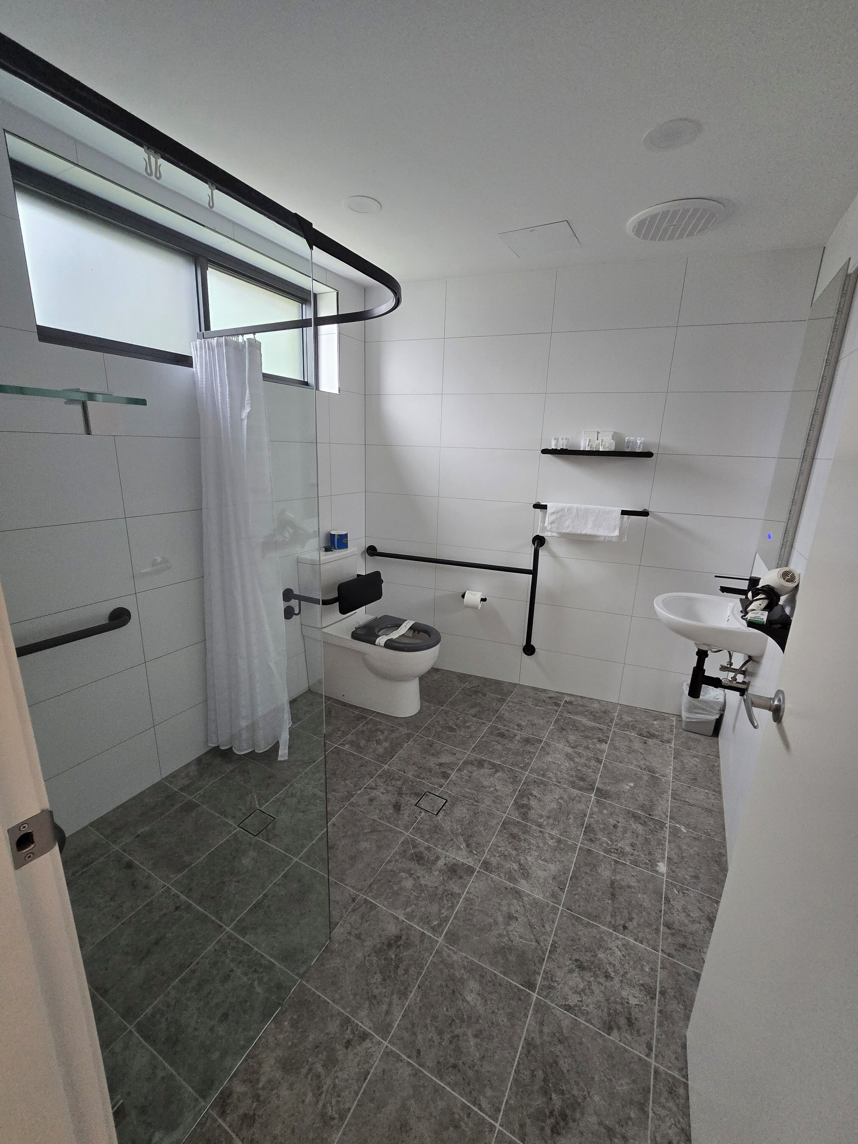Un bagno moderno con il water, doccia e lavandino.