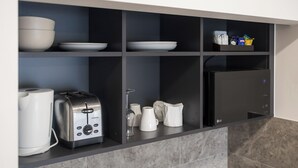 A kitchen with a built-in appliance, a coffee maker, a toaster, and a microwave. - Parkview Motor Inn Parkes (Parkes)