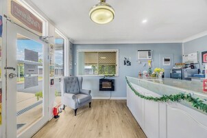 Una cocina moderna con una silla tapizada de gris, una estufa integrada y un ventanal con vistas al exterior.