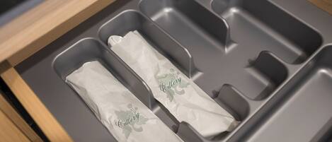 A drawer with three compartments, each containing a tissue with the word "Cutlery" printed on it.