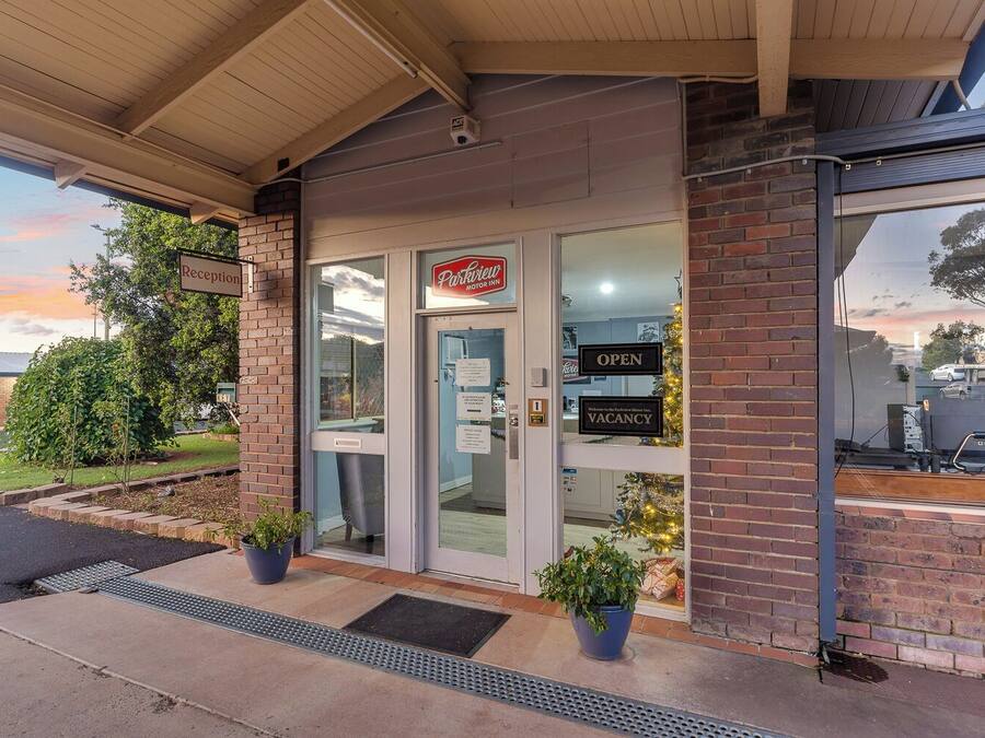 Un edificio con un cartel que dice "Reception" y "Park Inn Motor Inn".