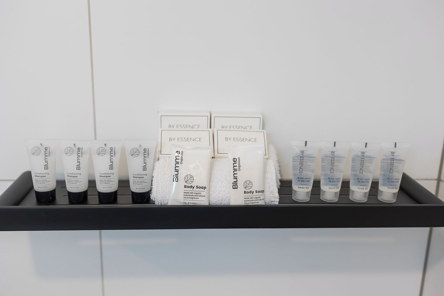 A shelf with various Blumme Organica products including shampoos, body soap, and body wash.