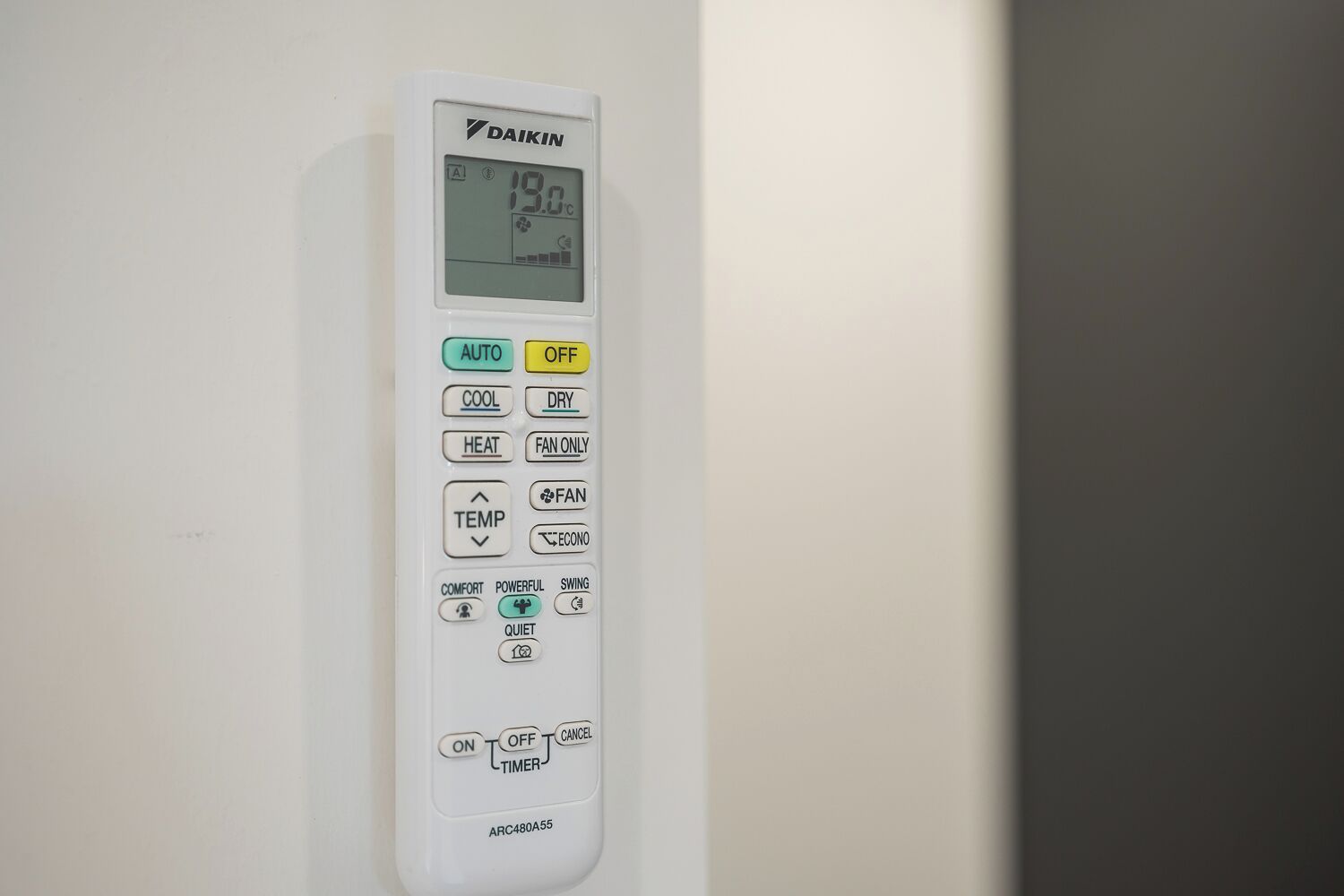 A Daikin air conditioner control panel with temperature display and various operational buttons.