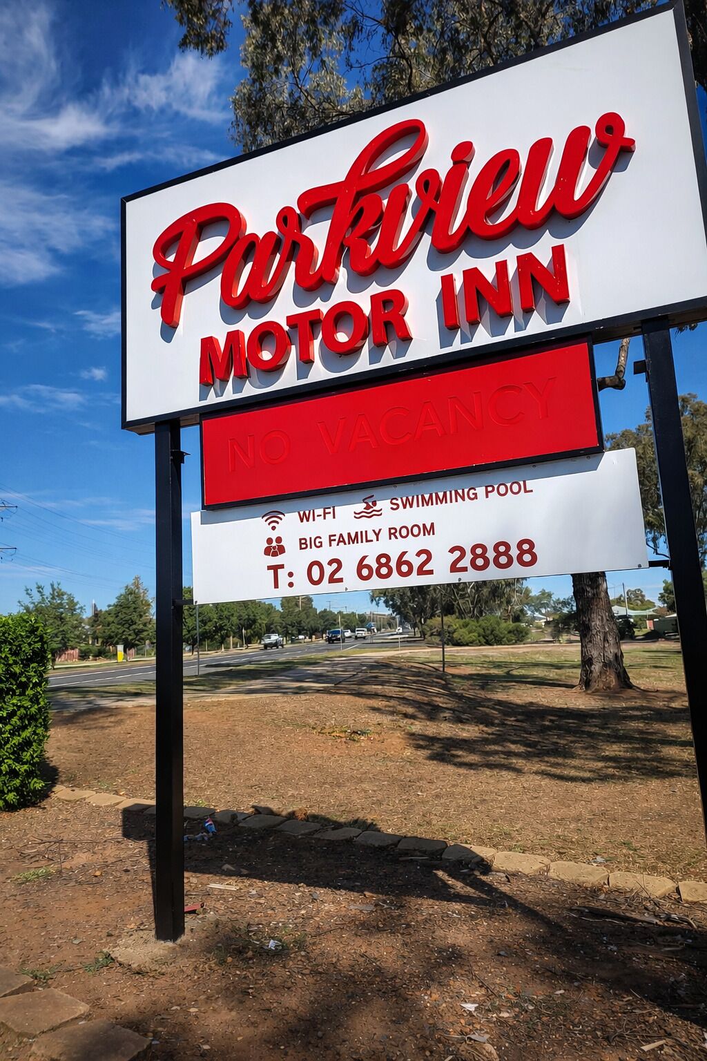 A sign for 'Purkiew Motor Inn' with amenities like Wi-Fi, a swimming pool, and a big family room.