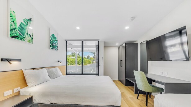 A modern hotel room with a large bed, a desk, a chair, and a TV. - Parkview Motor Inn Parkes (Parkes)