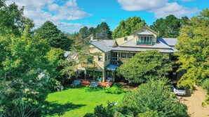 A large house with a spacious backyard, a covered patio, and a car parked nearby. - Leura House (Leura)