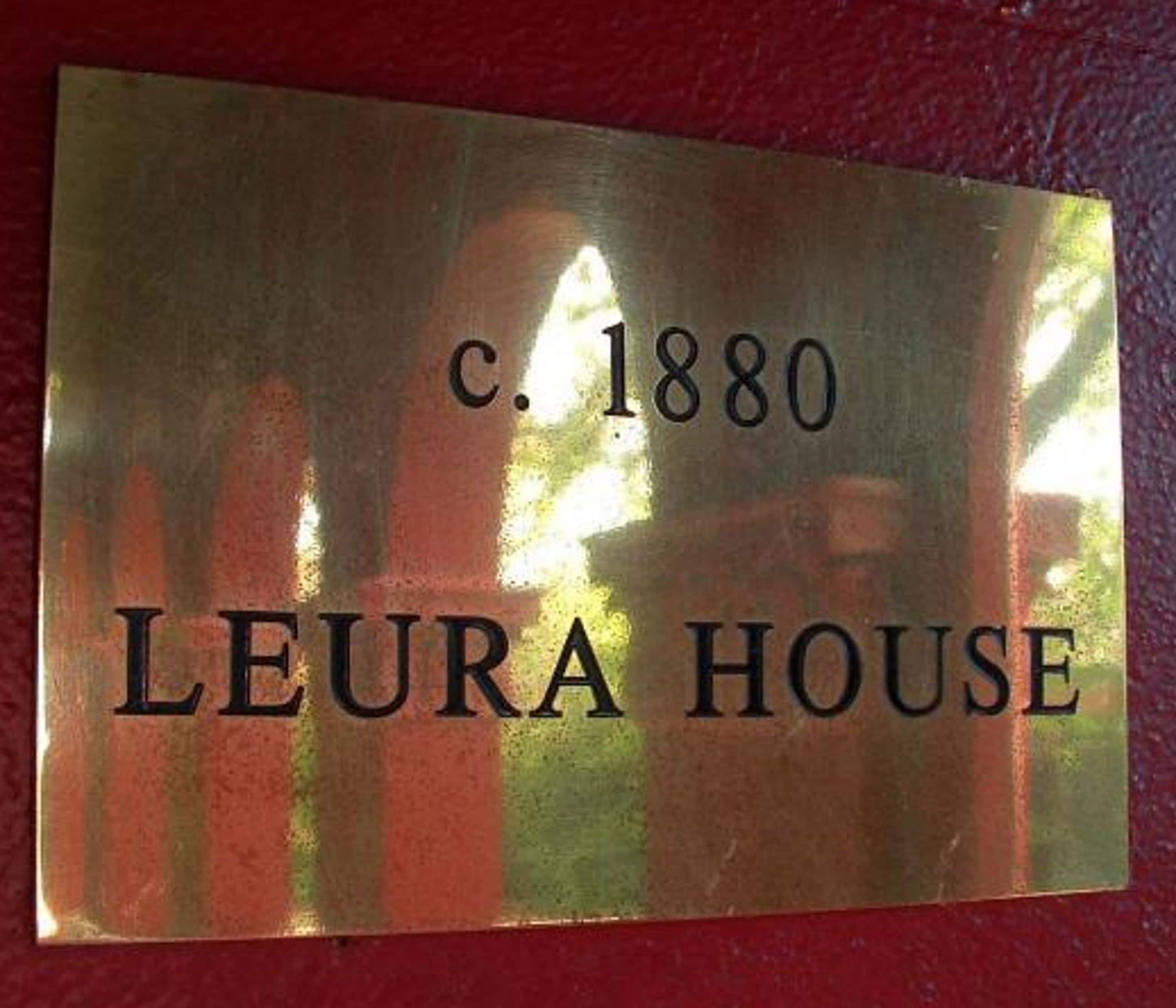 A brass plaque with the inscription "c. 1880 LEURA HOUSE".