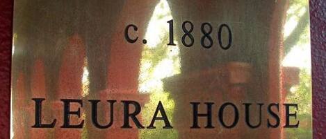 A brass plaque with the inscription "c. 1880 LEURA HOUSE".