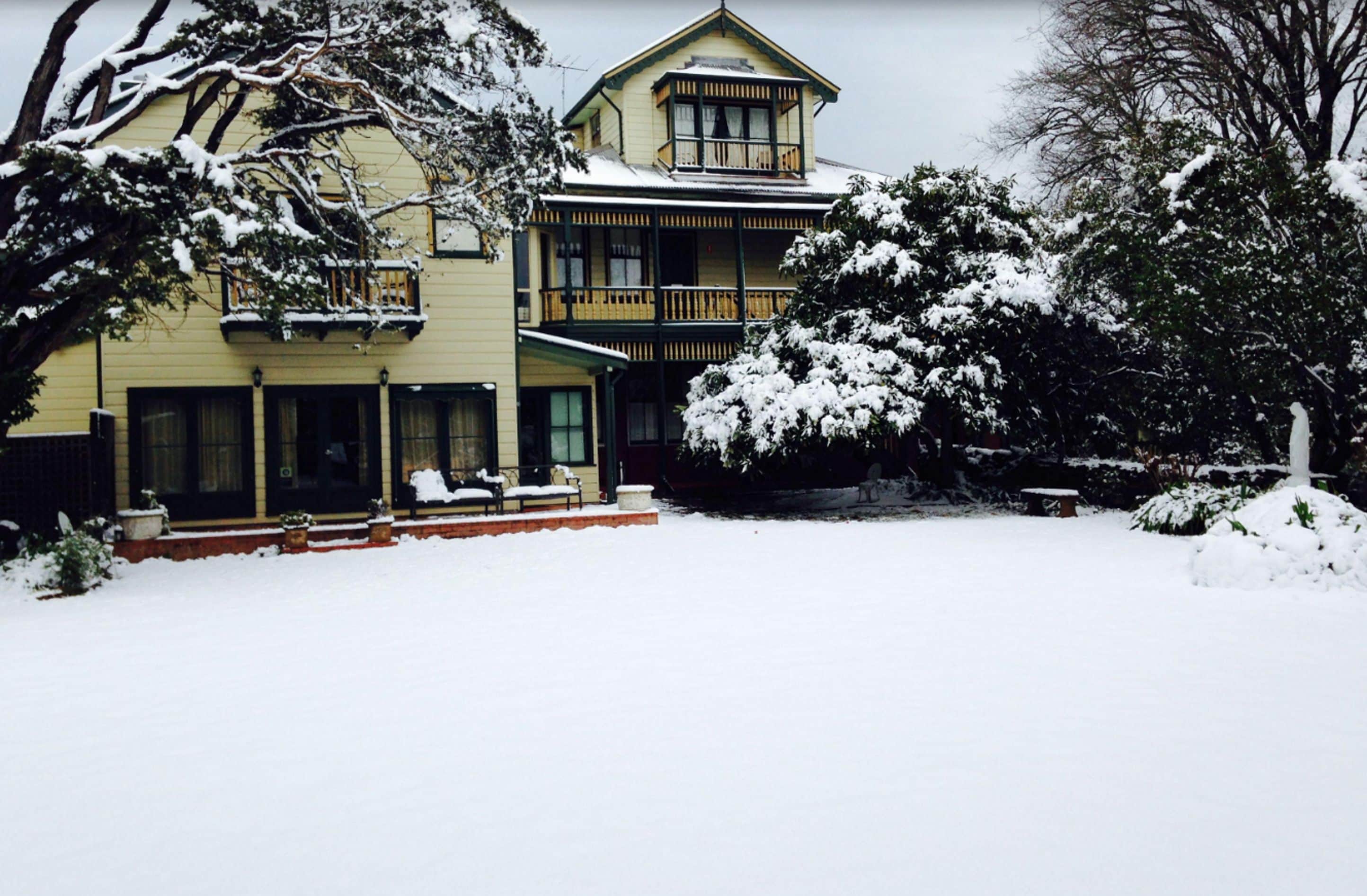 A two-story house with a balcony and a covered porch area.