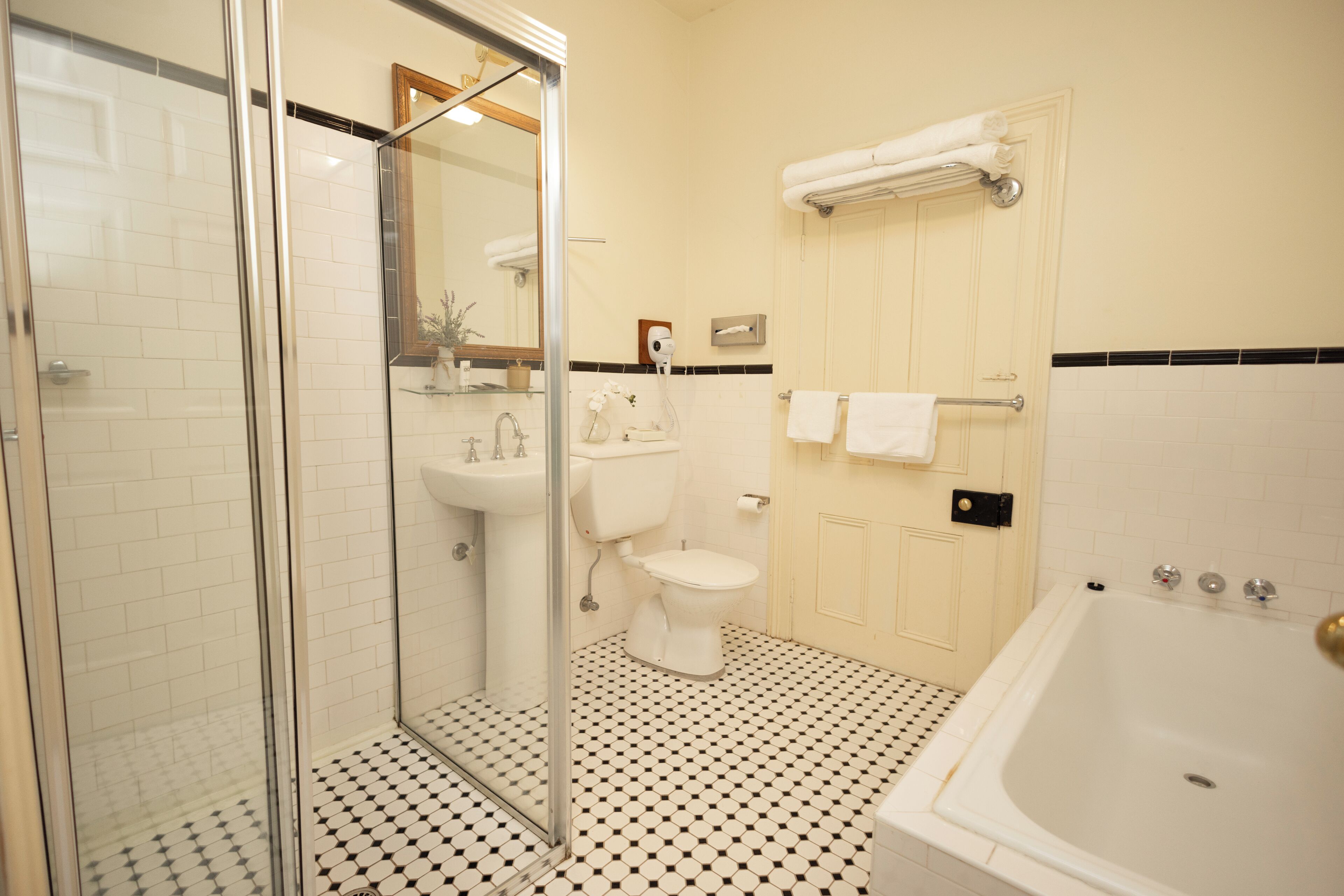 Un baño con cabina de ducha de vidrio, un lavabo blanco, un inodoro y una bañera.