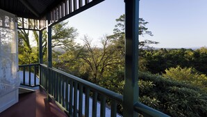 A covered balcony with a view of a forested area. - Leura House (Leura)