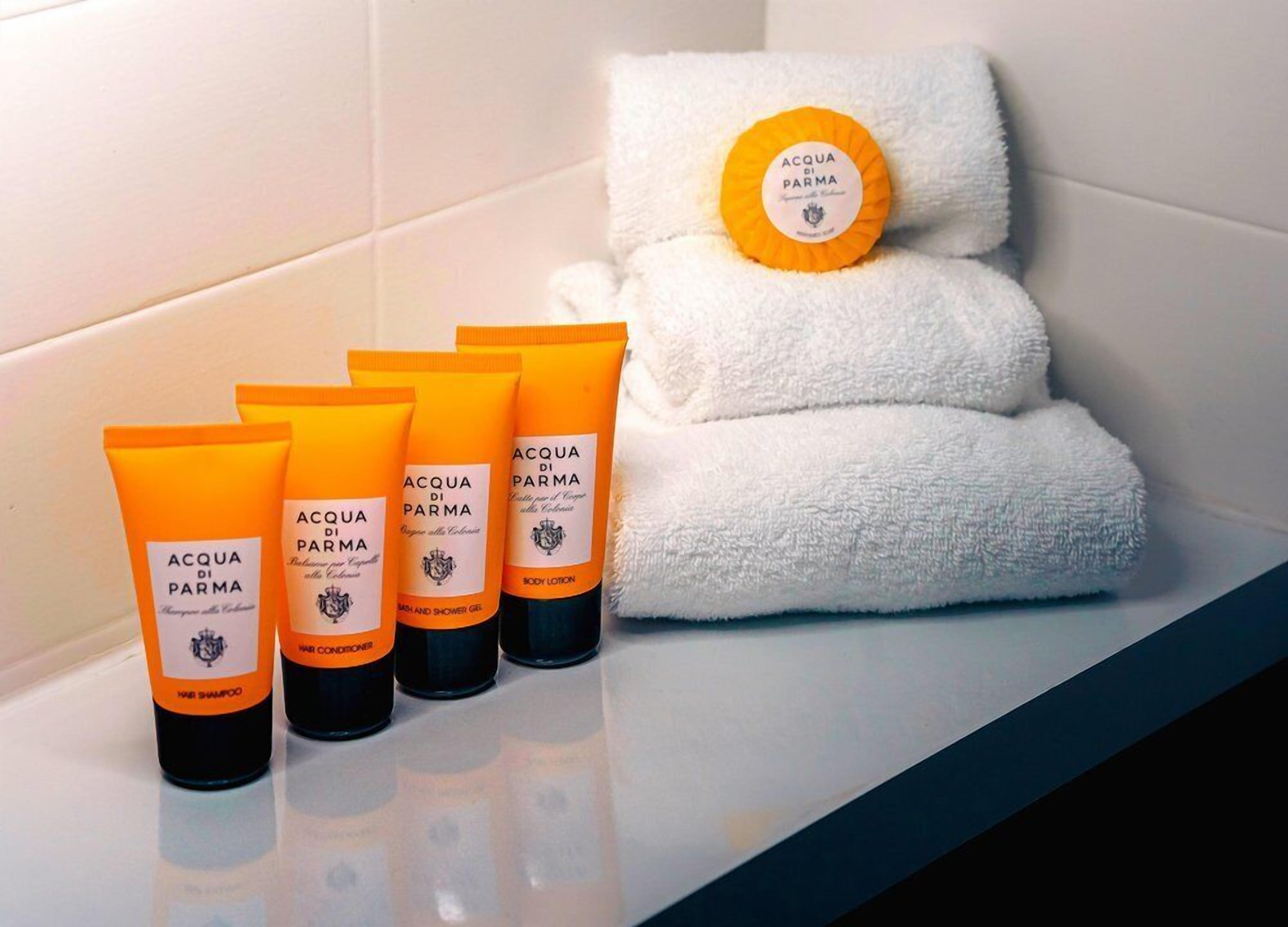 Un bagno con articoli da toilette, tra cui lozione corpo, shampoo e balsamo.