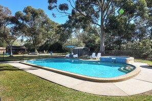 A rectangular swimming pool with a tiled edge, surrounded by a grassy area and a fence. - Greenacres Motel (Corowa)