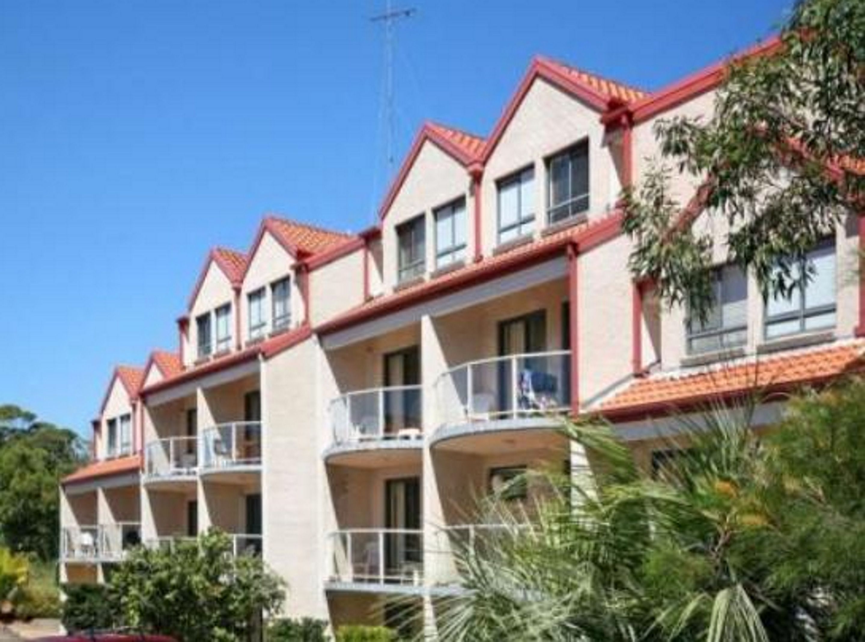 Una hilera de edificios de dos plantas con balcones, probablemente un hotel o resort.
