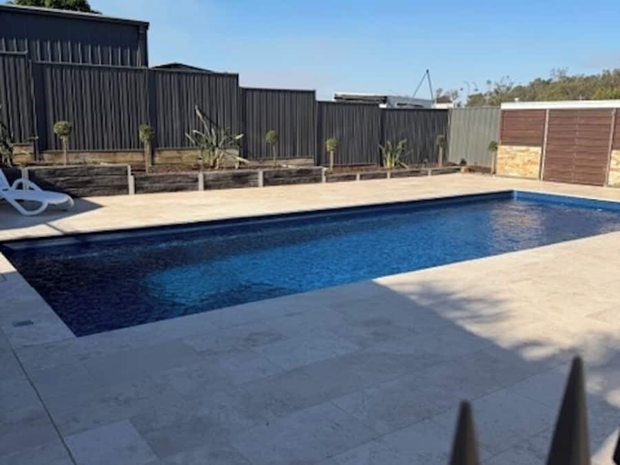 Una piscina al aire libre, sillones reclinables de piscina